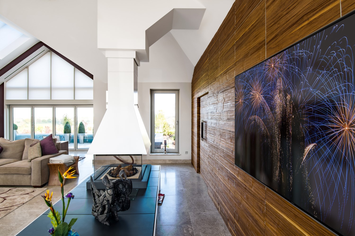 Sideview of cinema room with TV revealed from wooden wall panel.